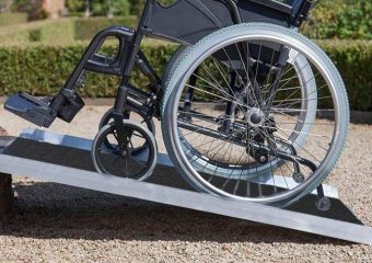 A close-up photo of a wheelchair and a wheelchair ramp.